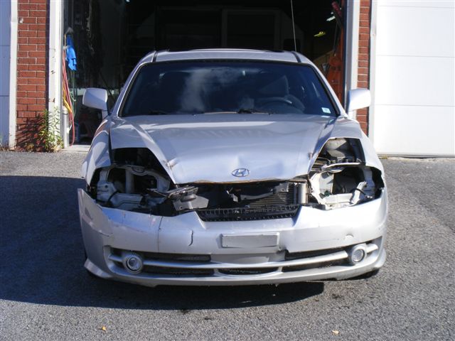 Panneaux et pare‑chocs en attente de réparation dans un atelier de carrosserie à Saint-Constant 