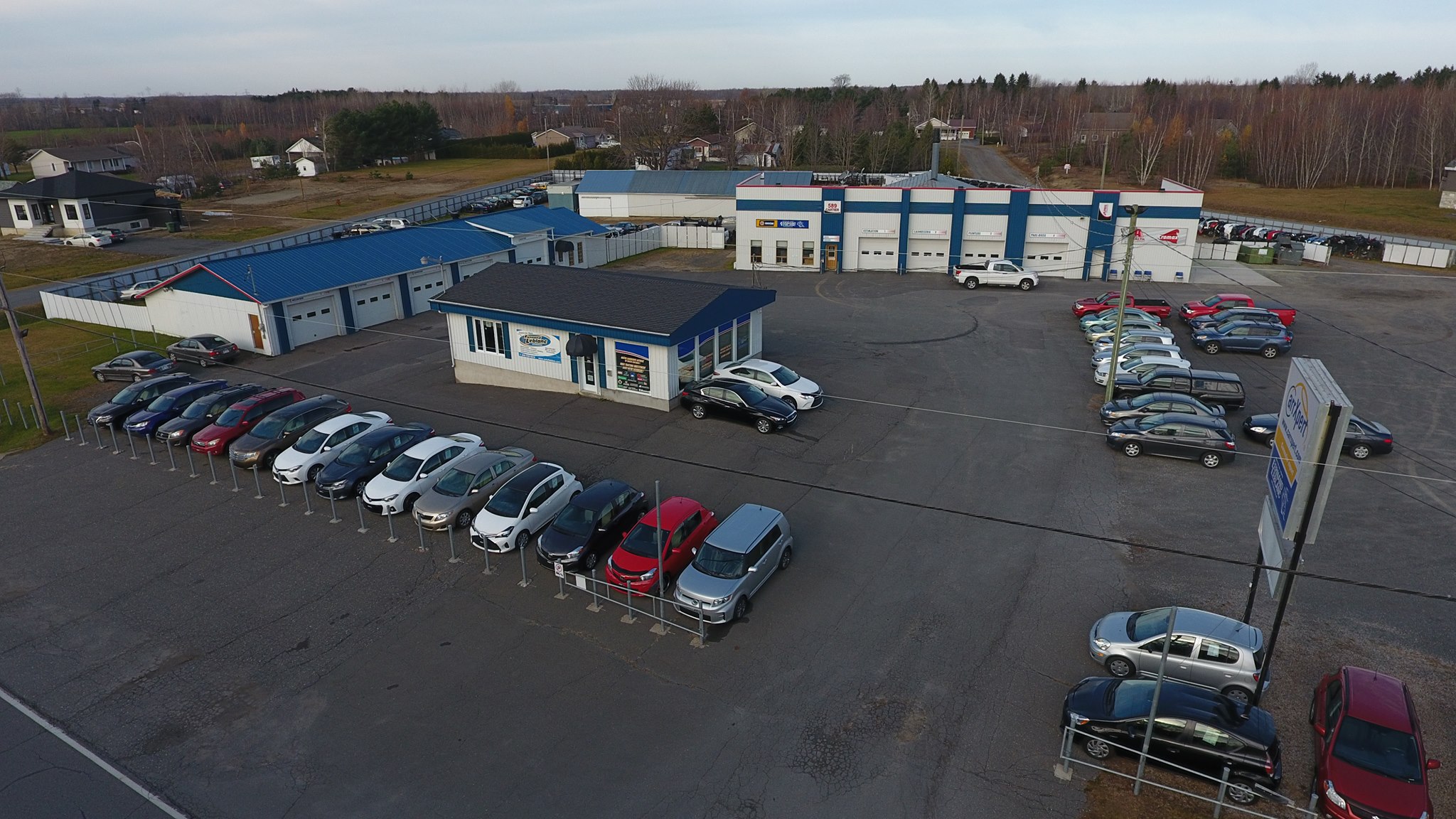 Carrossier ponçant un panneau de carrosserie dans un atelier à Victoriaville