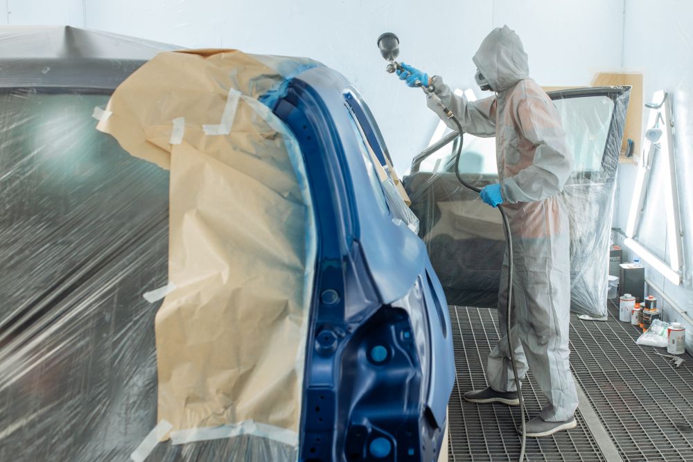  Carrossier ponçant un panneau de carrosserie dans un atelier en Abitibi-Témiscamingue 